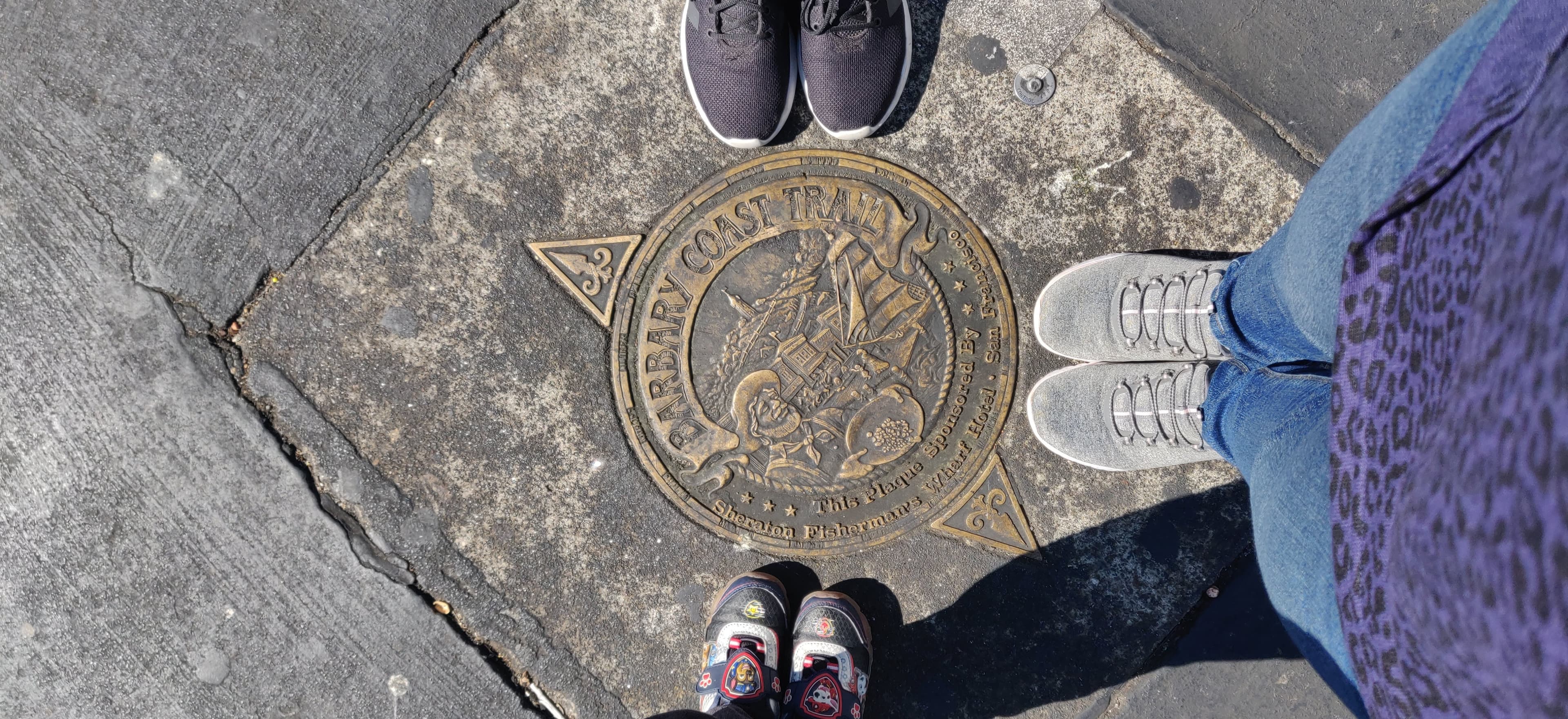 Decorative circular manhole cover photographed on a city pavement