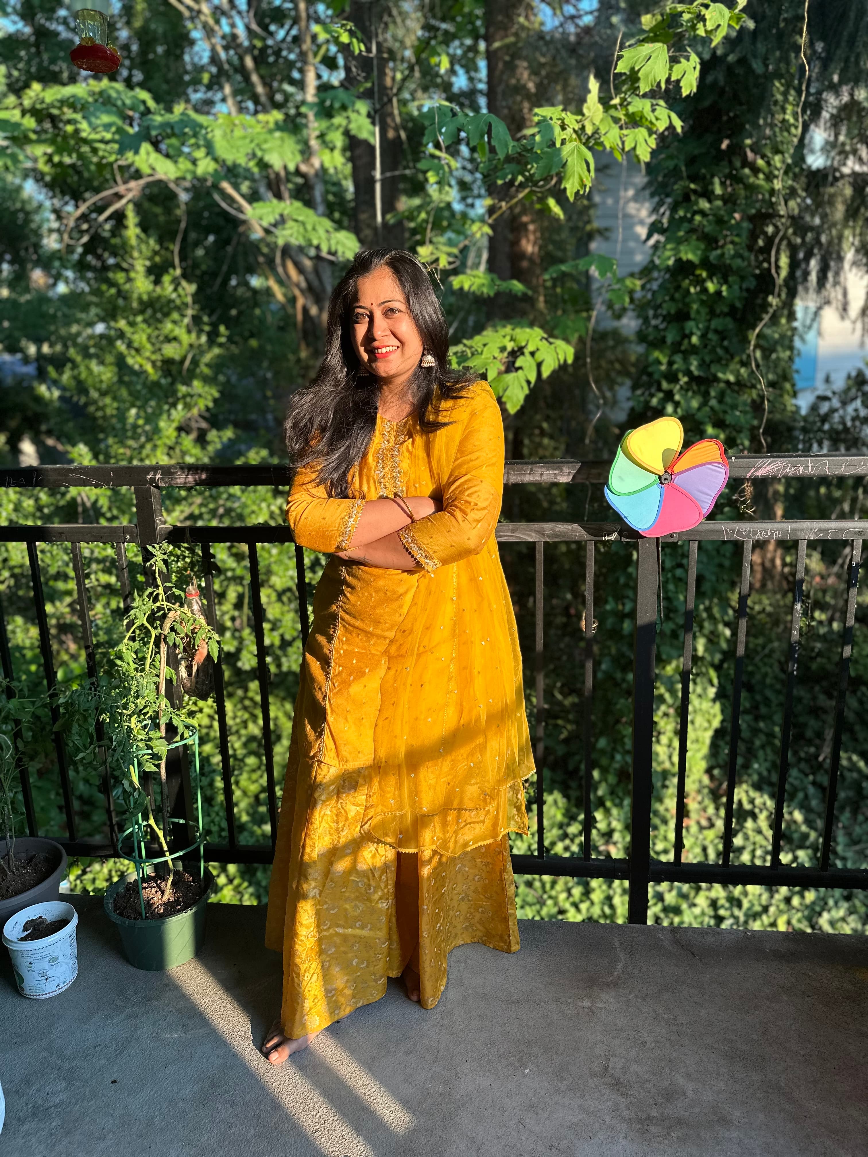 Manasi in yellow, surrounded by the green Pacific Northwest landscape